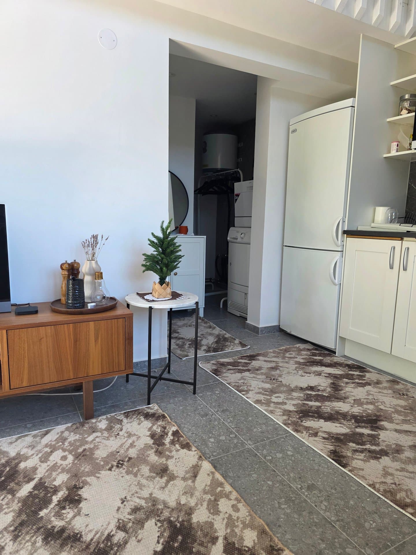 Modernt och ljust kök med helt utrustad inredning, integrerad kylskåp och en bekväm matplats. Skandinavisk design möter funktionalitet i denna charmiga gästhus.